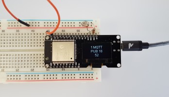 The OLED shows the latest measured value and MQTT status.