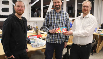 Glückwünsche und Präsente überreicht durch Mathias Claußen (Elektor, rechts) an Ian Hubbertz (Mitte) und Michael Mosburger (links).