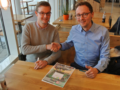 Udo Bormann (Elektor, links) und Matthias Wilkens (NXP) beschließen die Zusammenarbeit beim NXP-Cup für europäische Schulen und Universitäten mit einem Vertrag und einem Handschlag.