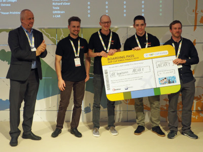 De winnaars van de NXP-Cup 2019 kregen van Rolf Nissen (links, NXP) een vliegticket overhandigd. Afbeelding: Elektor / TS