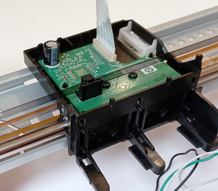 Print head assembly with belt, optical tape and optical sensor. The controller on the PCB was removed to avoid potential faults.