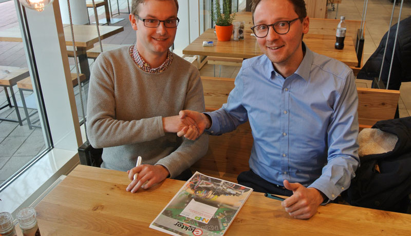 Udo Bormann (Elektor, links) und Matthias Wilkens (NXP) beschließen die Zusammenarbeit beim NXP-Cup für europäische Schulen und Universitäten mit einem Vertrag und einem Handschlag.