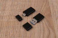 De USB-adapter voor B&O Beoplay Portal voor PC en PlayStation - met een adapter van USB-C naar USB-A. Beide met een dopje. 