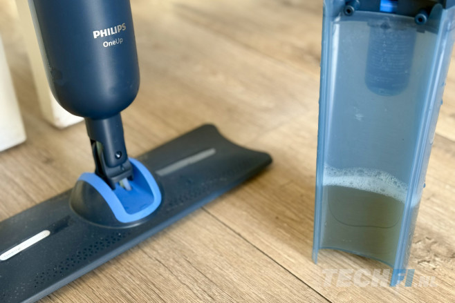 De Philips OneUp 3000 is een elektrische dweil. Een pompsysteem leidt schoon water met reinigingsmiddel naar de dweil, en voert vuil water af naar een apart reservoir.